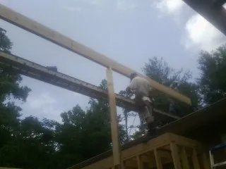 Carpenter setting a ridge beam over a new addition frame — Ice Dam Removal by Roofing Brothers in Weatherford