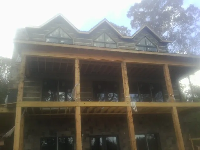 Dormers and porch framing on a large log home under construction — Roof Coating work by our crew in Weatherford